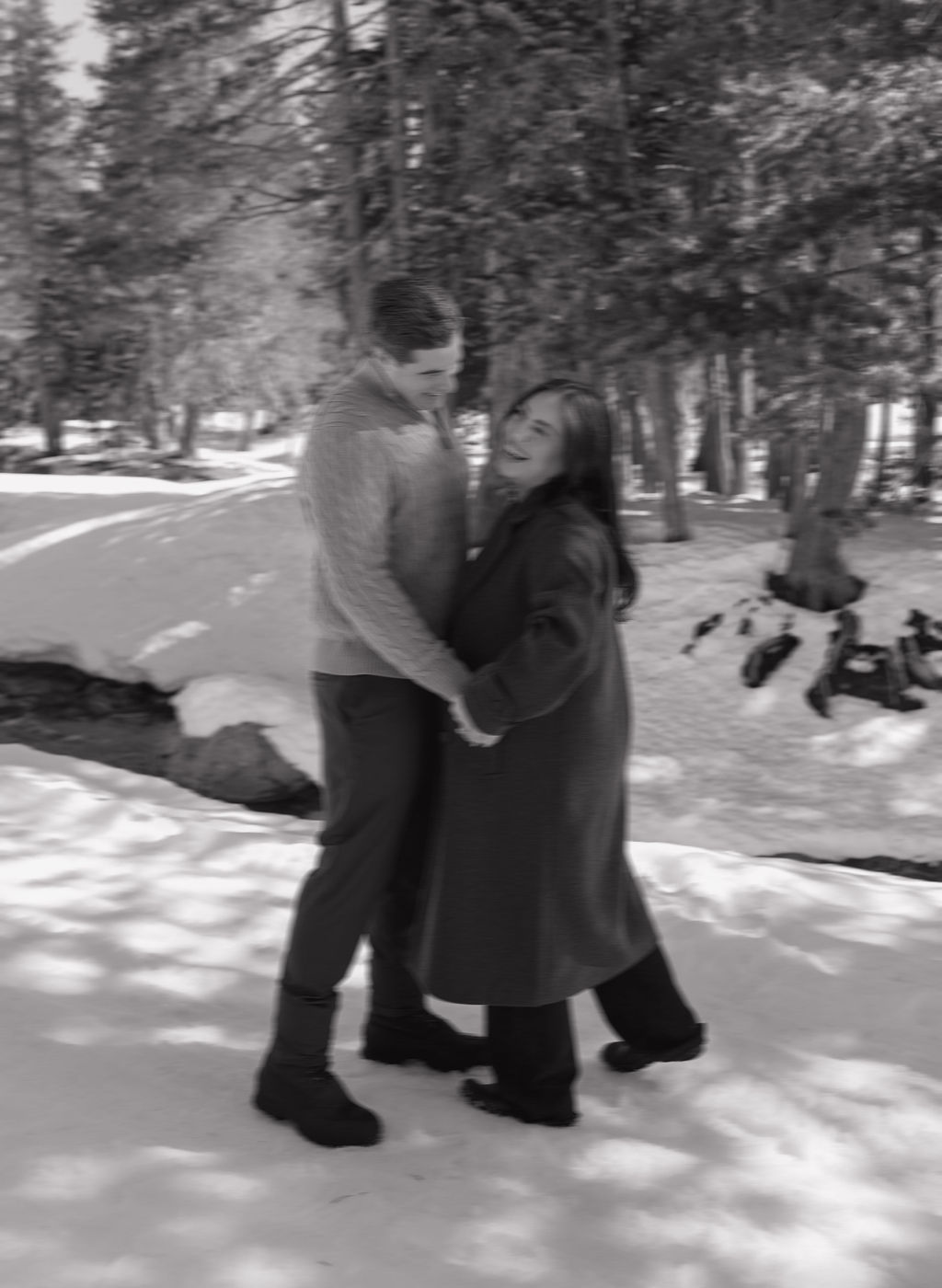 A couple posing for engagement photos in the snow