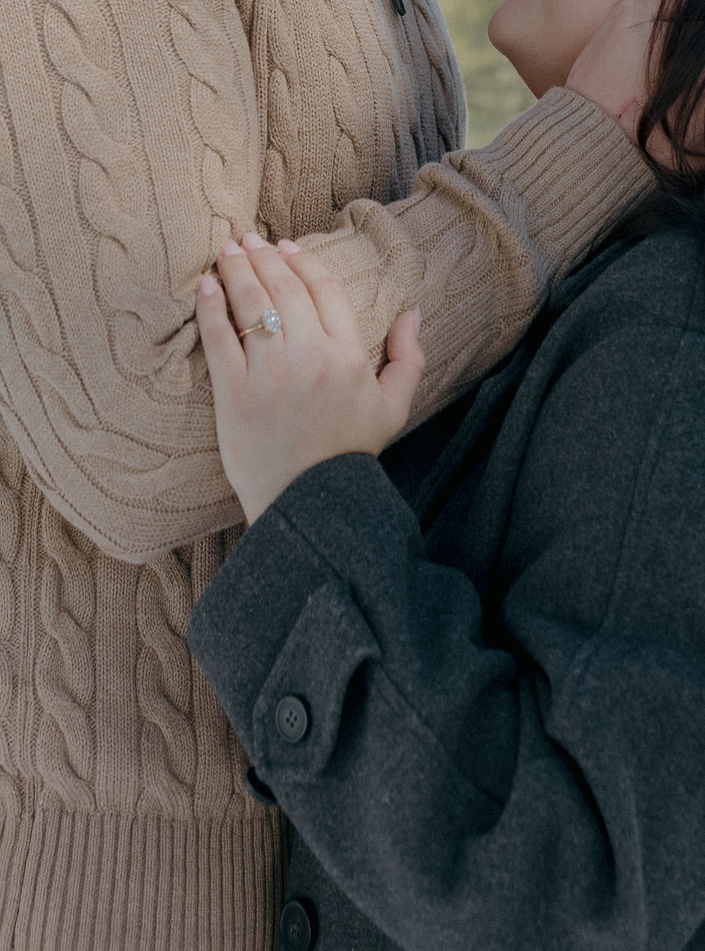 A couple in sweaters and jackets as their winter engagement photo outfits