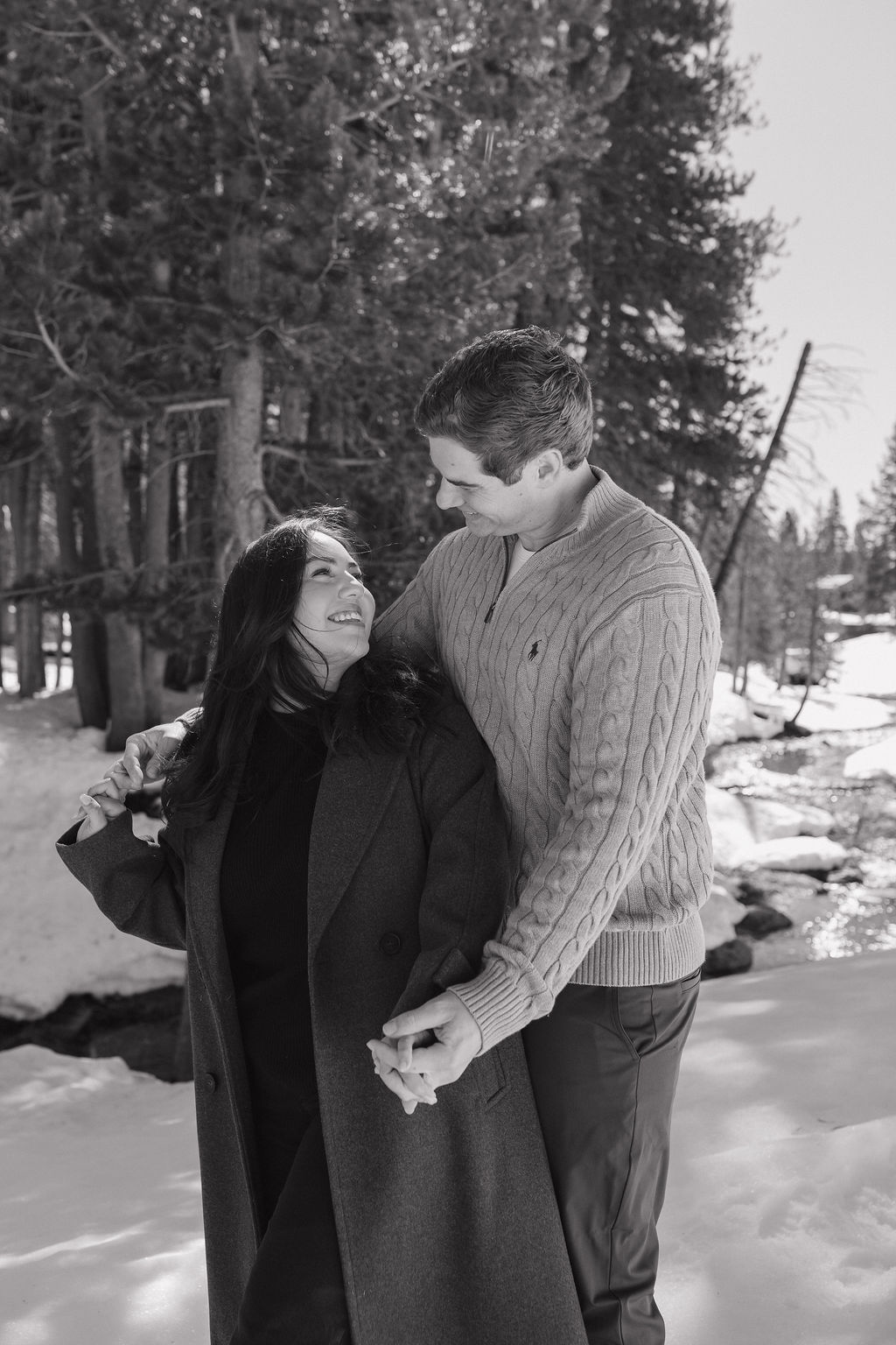A couple taking snowy engagement photos