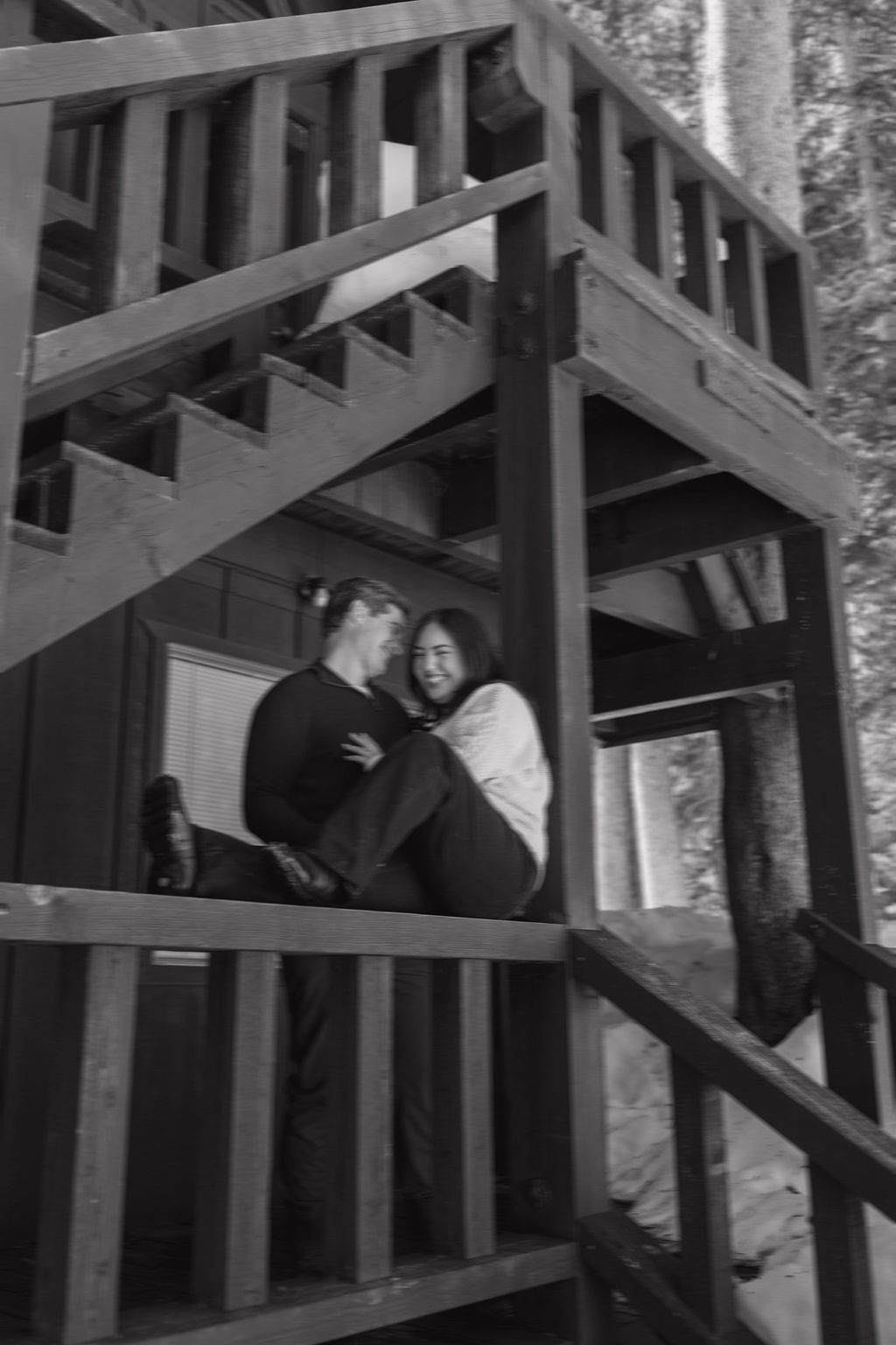 A couple posing for engagement photos at a cabin