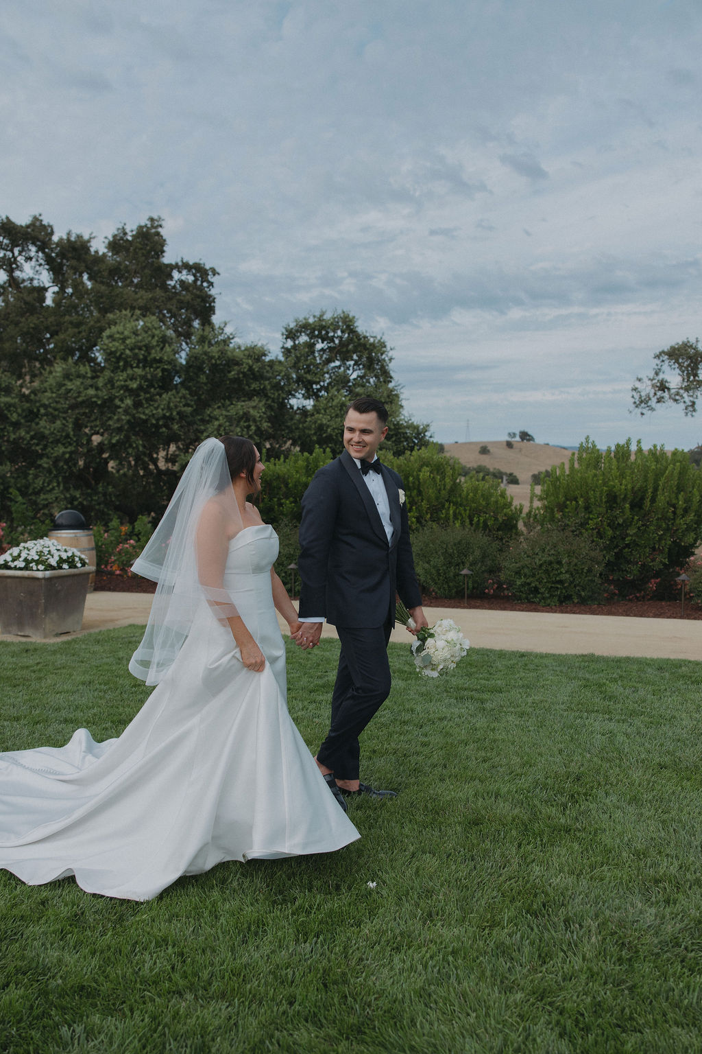 A bride and groom walking through CordeValle Winery