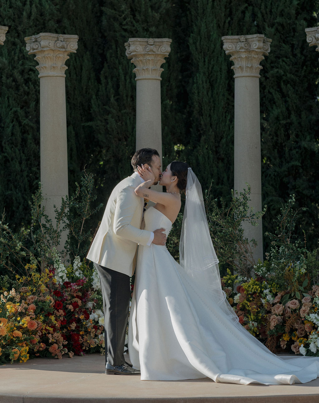 A bride and groom kissing during their wedding ceremony