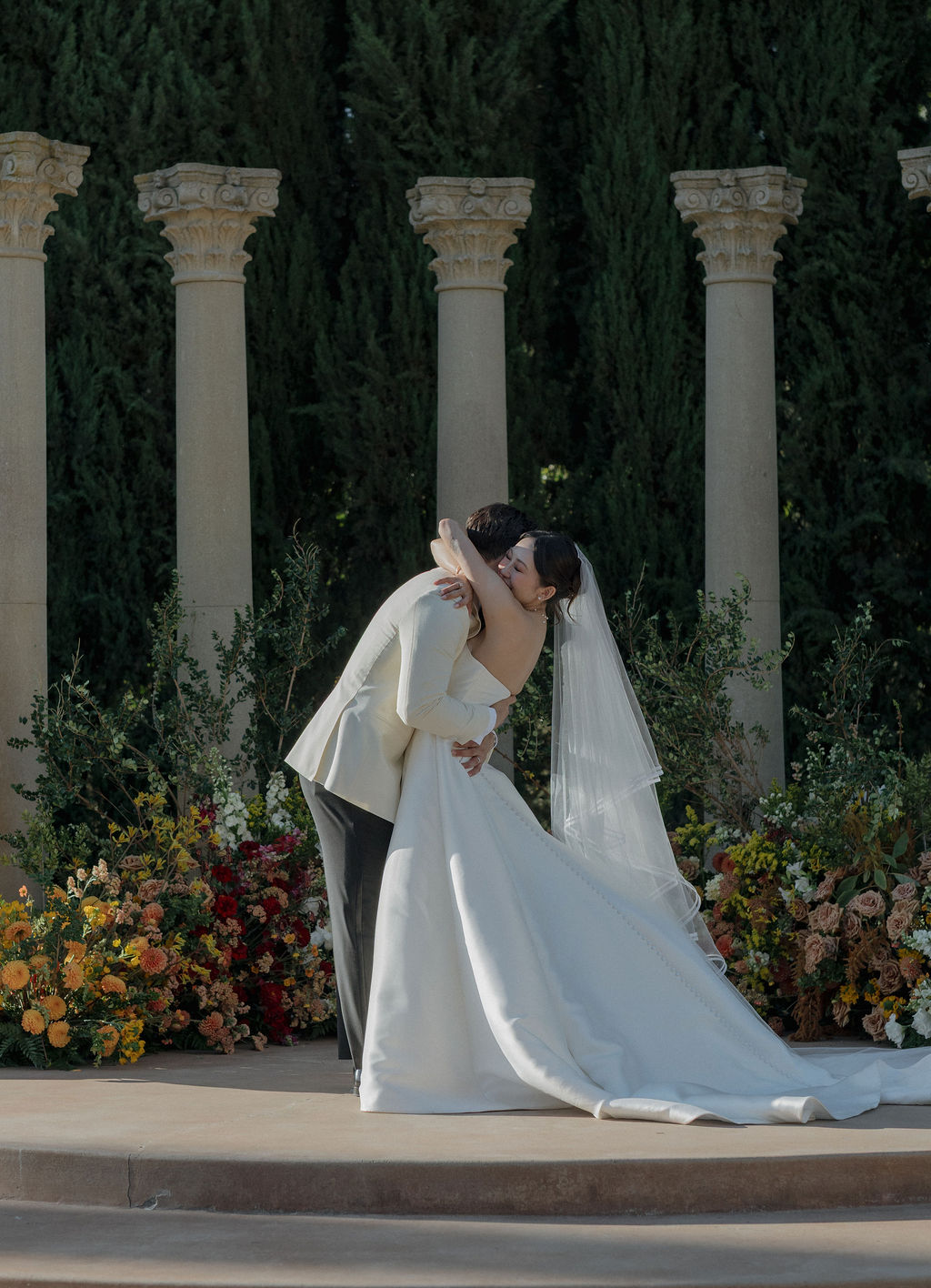 A bride and groom kissing during their wedding ceremony