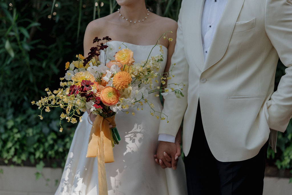 A bride and groom holding hands at their fall wedding