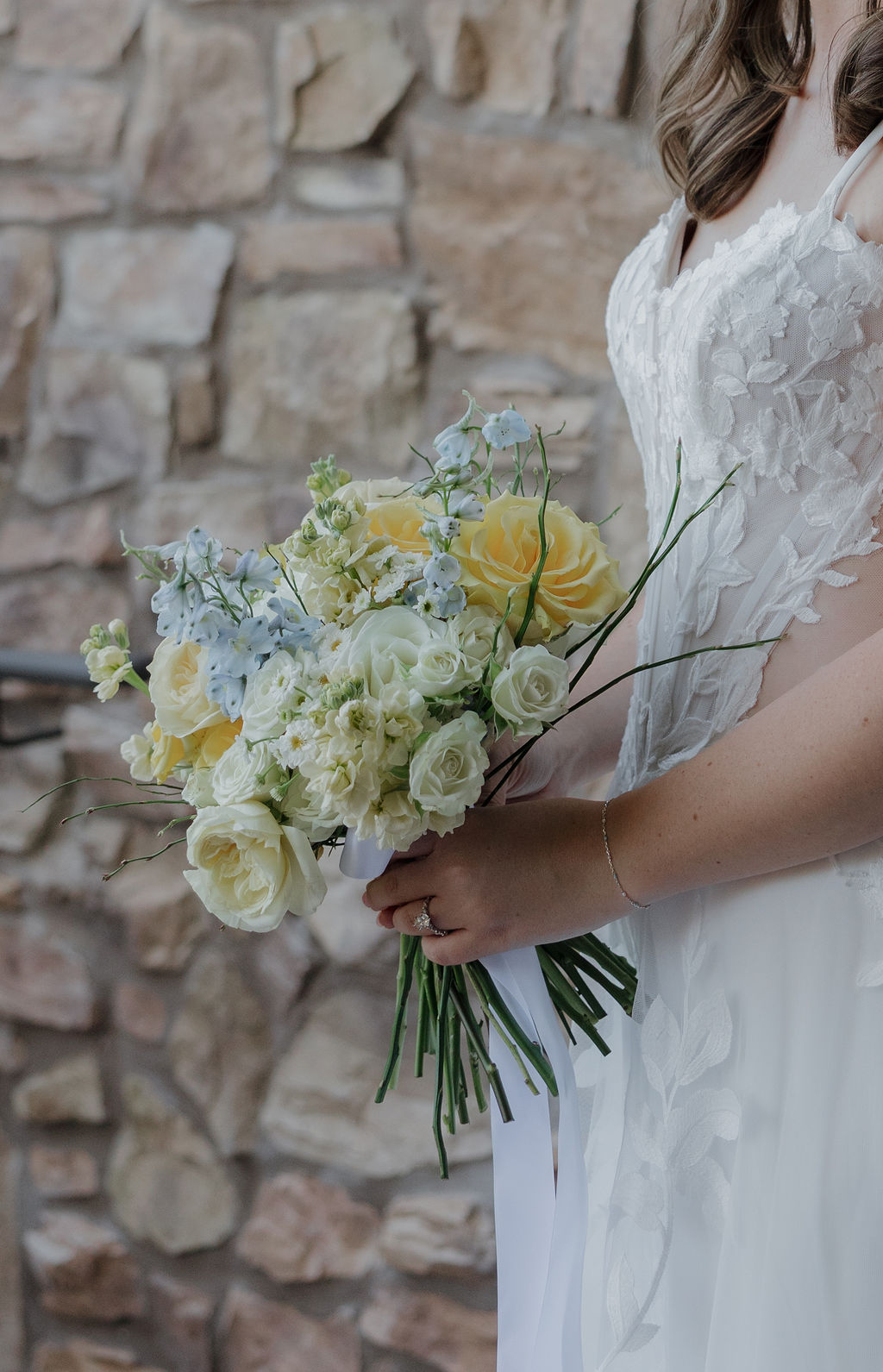 A bride holding a yellow wedding bouquet