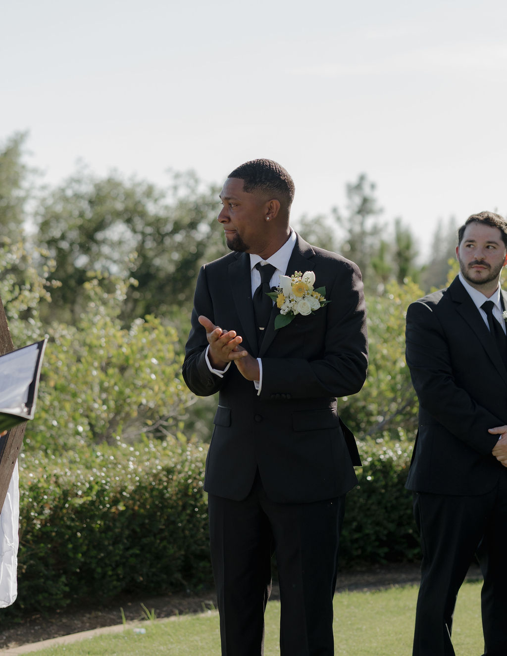 A groom crying watching a bride walk down the aisle