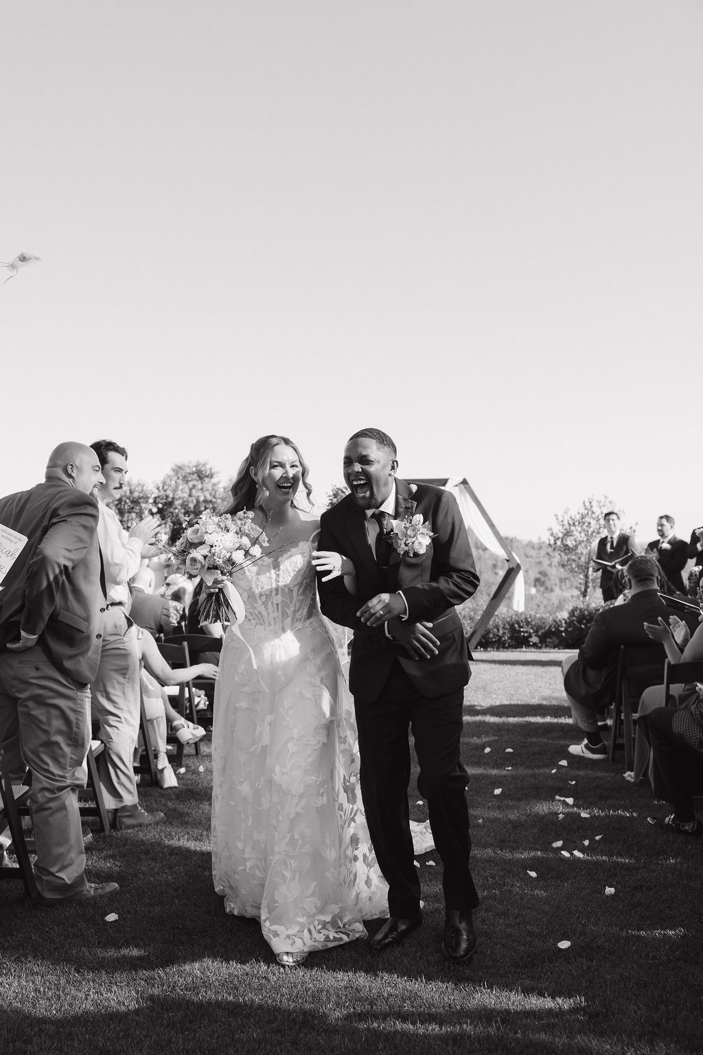 A bride and groom cheering after their wedding ceremony