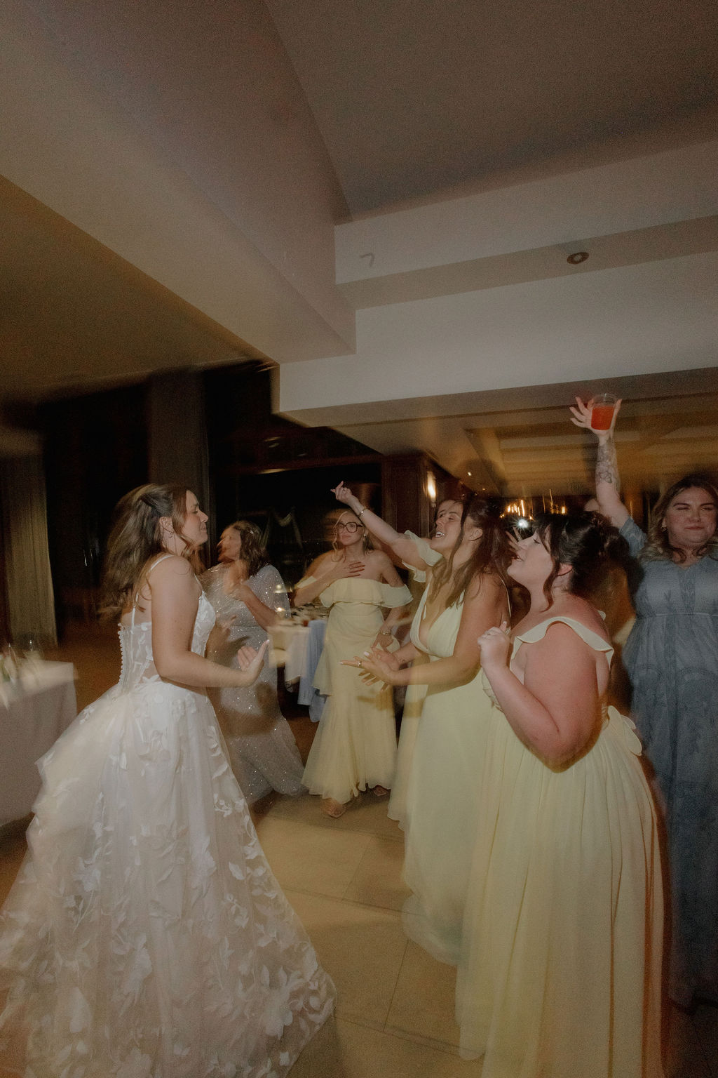 A bride dancing with bridesmaids on the dance floor